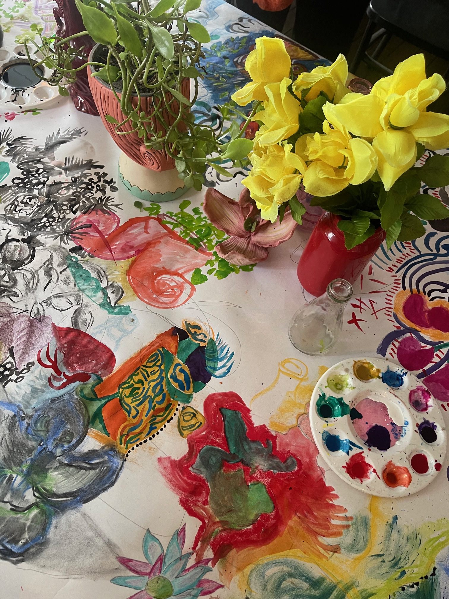 Close-up of painted workshop materials, flowers, and drawing table details